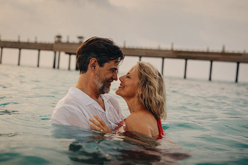 Mature couple enjoying a luxury vacation by the beach, embracing lasting love in retirement