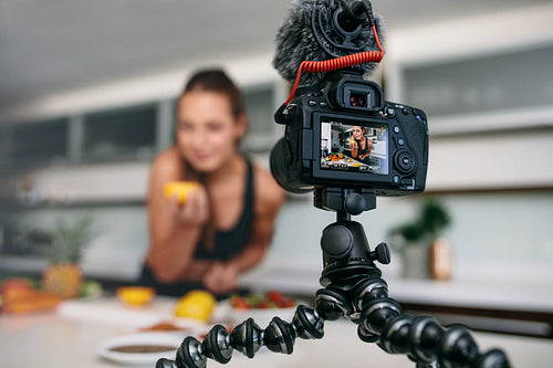 Young female blogger recording content for videoblog in Kitchen.