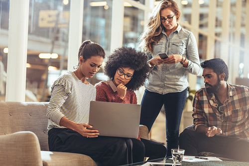 Business colleagues looking at a laptop in office