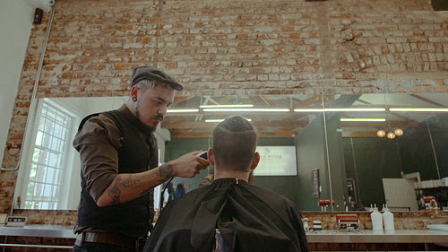 Barber giving a trendy haircut to client