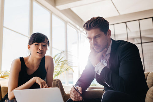 Young businesspeople working on laptop in office