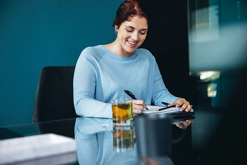 Business woman writing minutes during a meeting in a boardroom