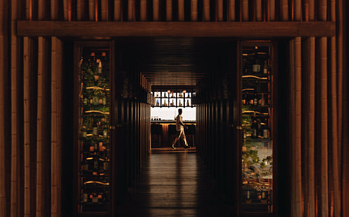 Elegant bar interior with warm lighting and a bartender at work