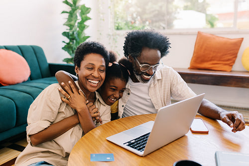Mom and dad watching movie with their daughter at home