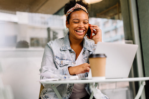 Happy businesswoman enjoying a phone call at a cafe