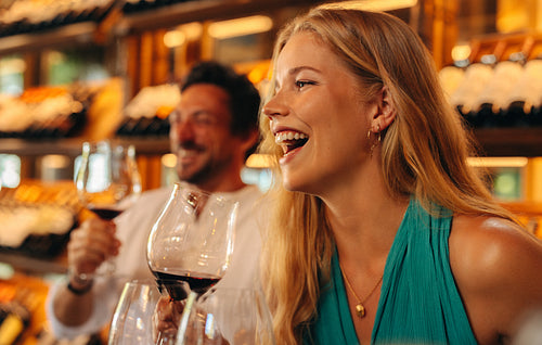 Happy couple enjoying wine tasting and laughing on holiday together