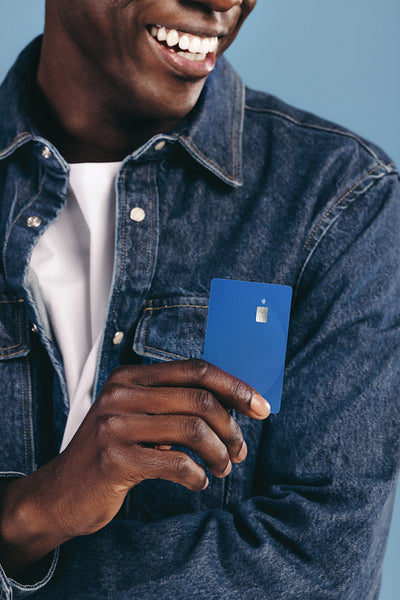 Paying with an easy tap. Young black man smiles while holding out his bank card
