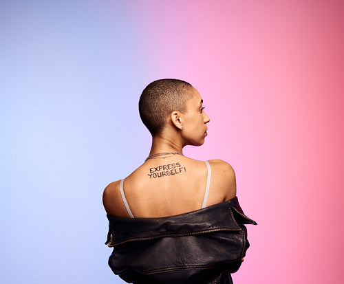 Shaved head woman with express yourself written on back