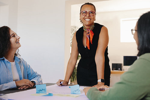 Smiling team members brainstorming ideas during a productive meeting at the office.