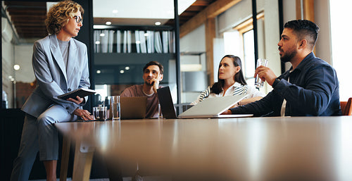 Business team discussing a project in a meeting. Group of business people sitting and talking in a boardroom