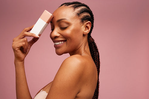 Beautiful woman with cosmetic product