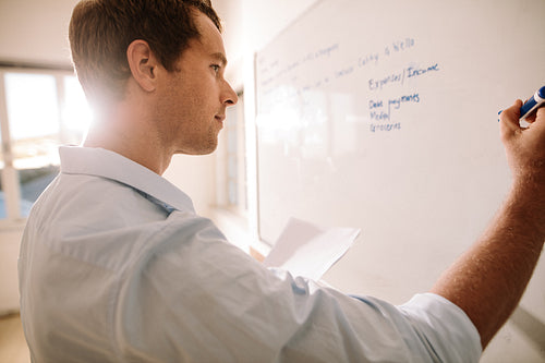Man writing on whiteboard with marker pen