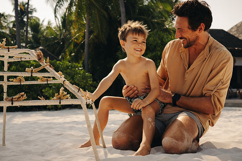 Playful father and son at luxury beach resort reef conservation activity