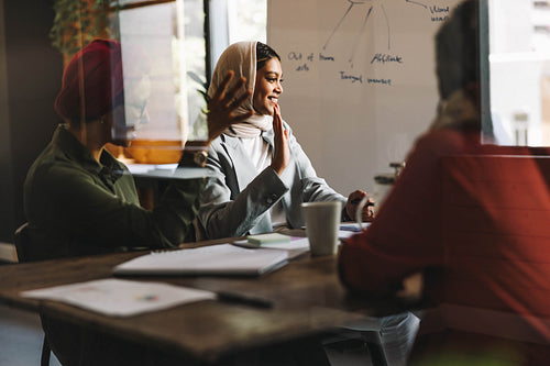 Happy Muslim businesswomen having a virtual meeting in an office