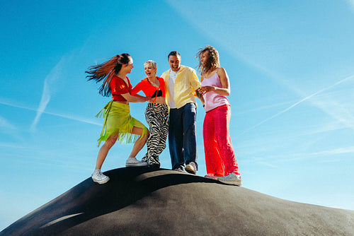 Friends walk together on a hilltop in a sunny outdoor adventure scene