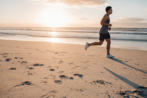 Fit young man running on the beach
