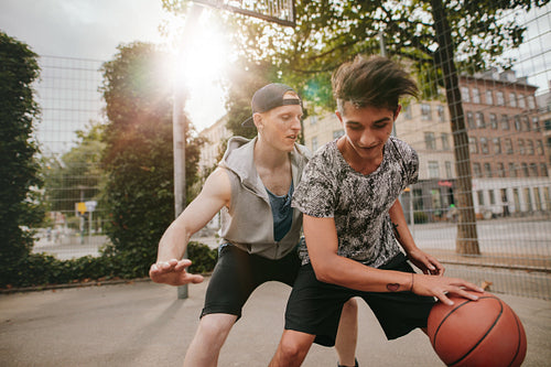 Friends playing basketball on outdoor court