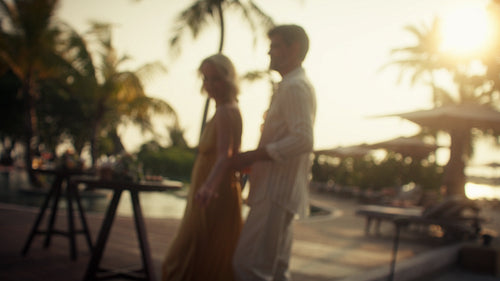 Couple dancing happily at a tropical resort during a beautiful sunset evening
