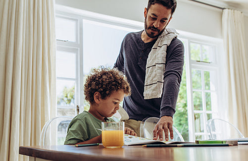 Father making his son do his school home work