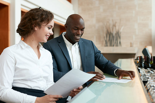 Happy young business people at cafe with some documents