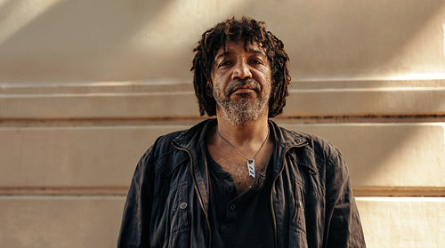 Confident homeless man looking at the camera outdoors