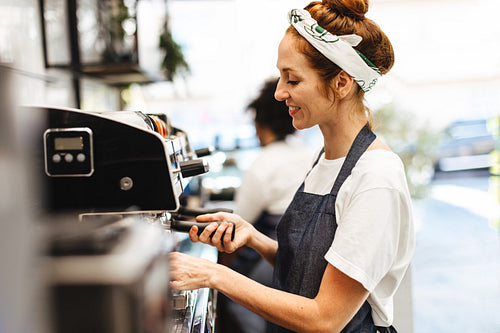 Barista brewing fresh coffee with a coffee machine