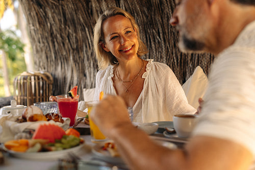 Smiling woman enjoying brunch at a luxury hotel with her partner
