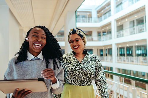 Coworkers walking and laughing in office building