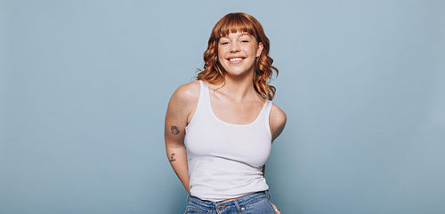 Woman with ginger hair standing against a studio background