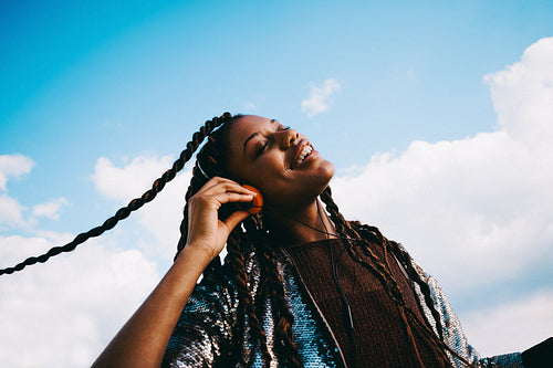 Smiling woman listens to music on headphones outdoors