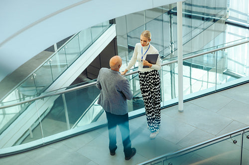 Business professionals discussing work in a modern office corridor