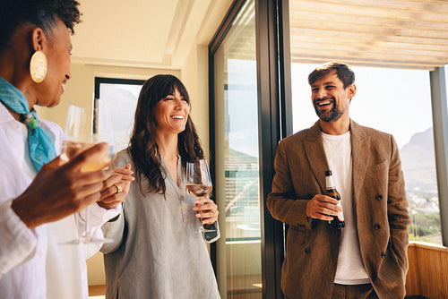 Friends enjoying a casual drink together at a modern home