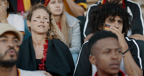 German soccer fans anxiously watching a game from stadium