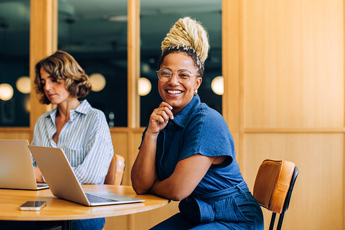 Professional women working and smiling in a modern office setting