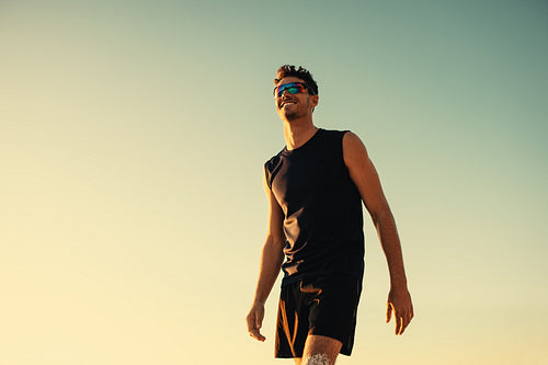 Pro athlete playing beach volleyball at sunset on coastal sand court
