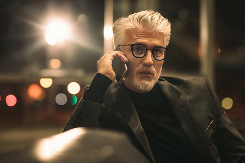 Senior businessman in office talking on mobile phone