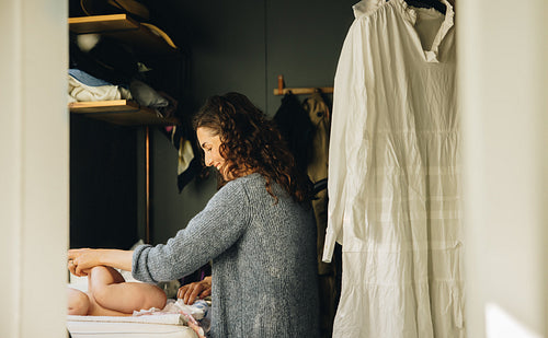 Mother changing baby diaper
