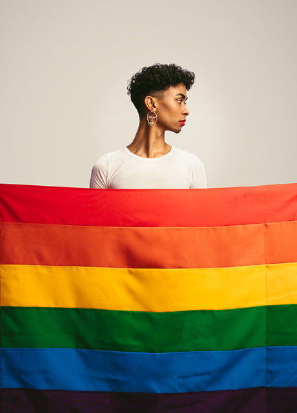 Transgender man behind gay pride flag