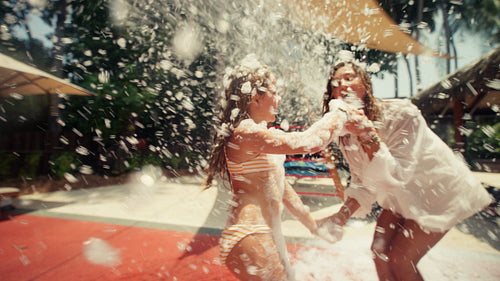 Mother and daughter enjoying a lively foam party during their summer vacation