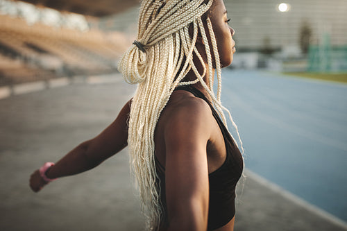 Female athlete warming up before a run in the stadium