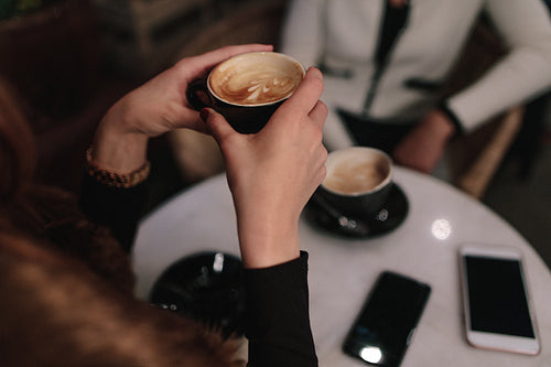 Woman having coffee with a friend at cafe