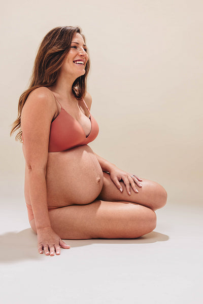 Expecting mother expressing body confidence in third trimester studio shoot