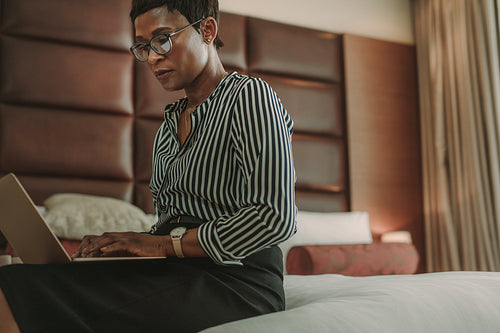 Businesswoman in hotel room working on laptop
