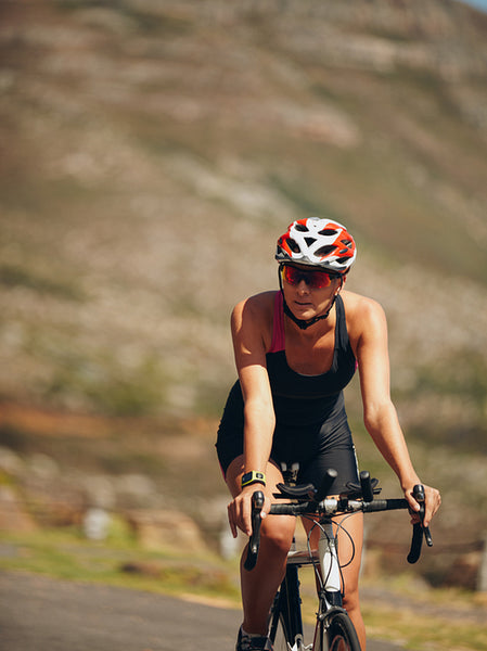Woman cycling on countryside road