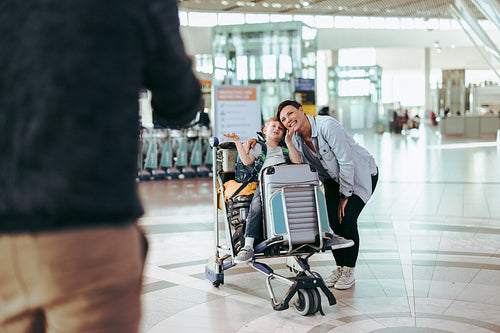 Family taking pictures at airport