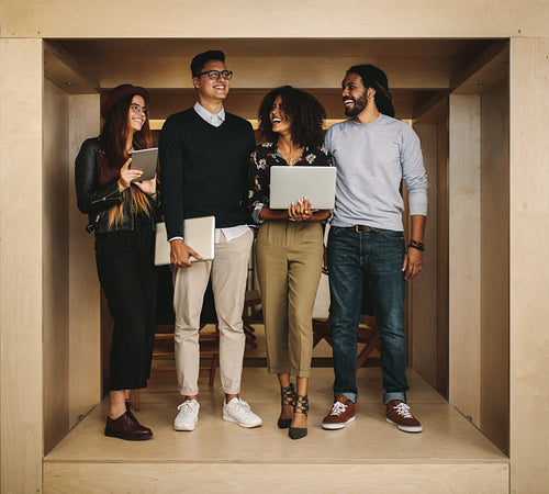 Business colleagues standing in office with laptops and tablet
