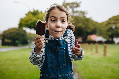 Adorable little girl enjoying eating ice cream