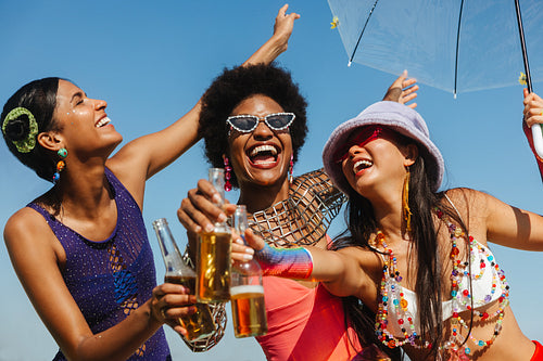 Friends celebrate at Brazilian carnaval with bottles