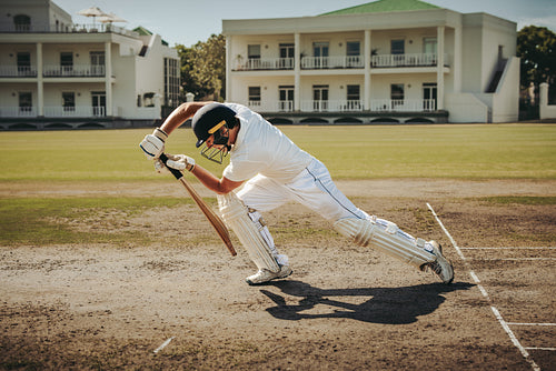 Male cricketer in action performing a shot during a match on the field