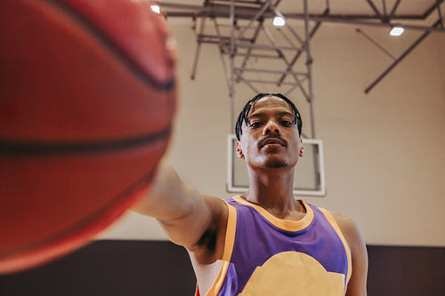 Basketball player holding ball in gym